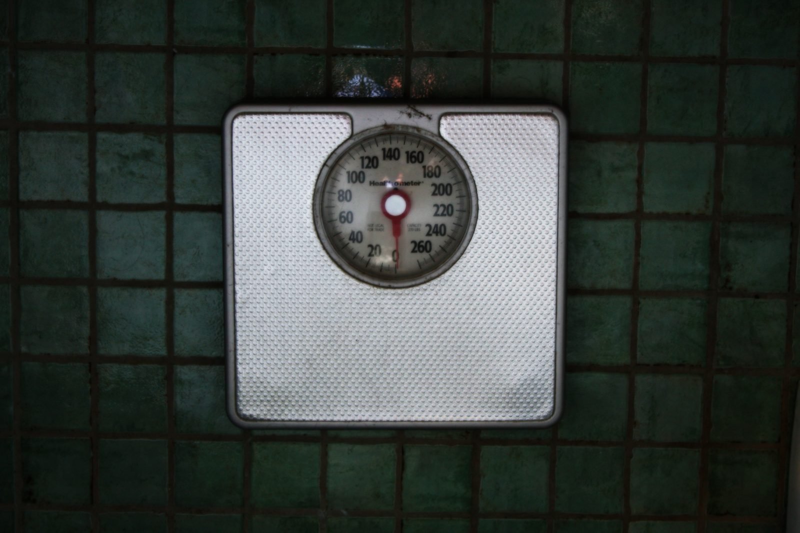 Digital bathroom scale sitting on a floor, used to track body weight