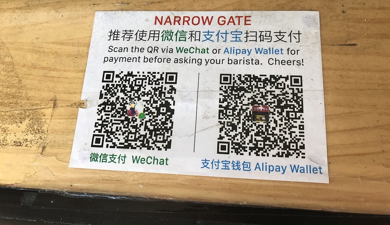 Printed QR codes displayed at a shop counter for scanning to make a mobile payment