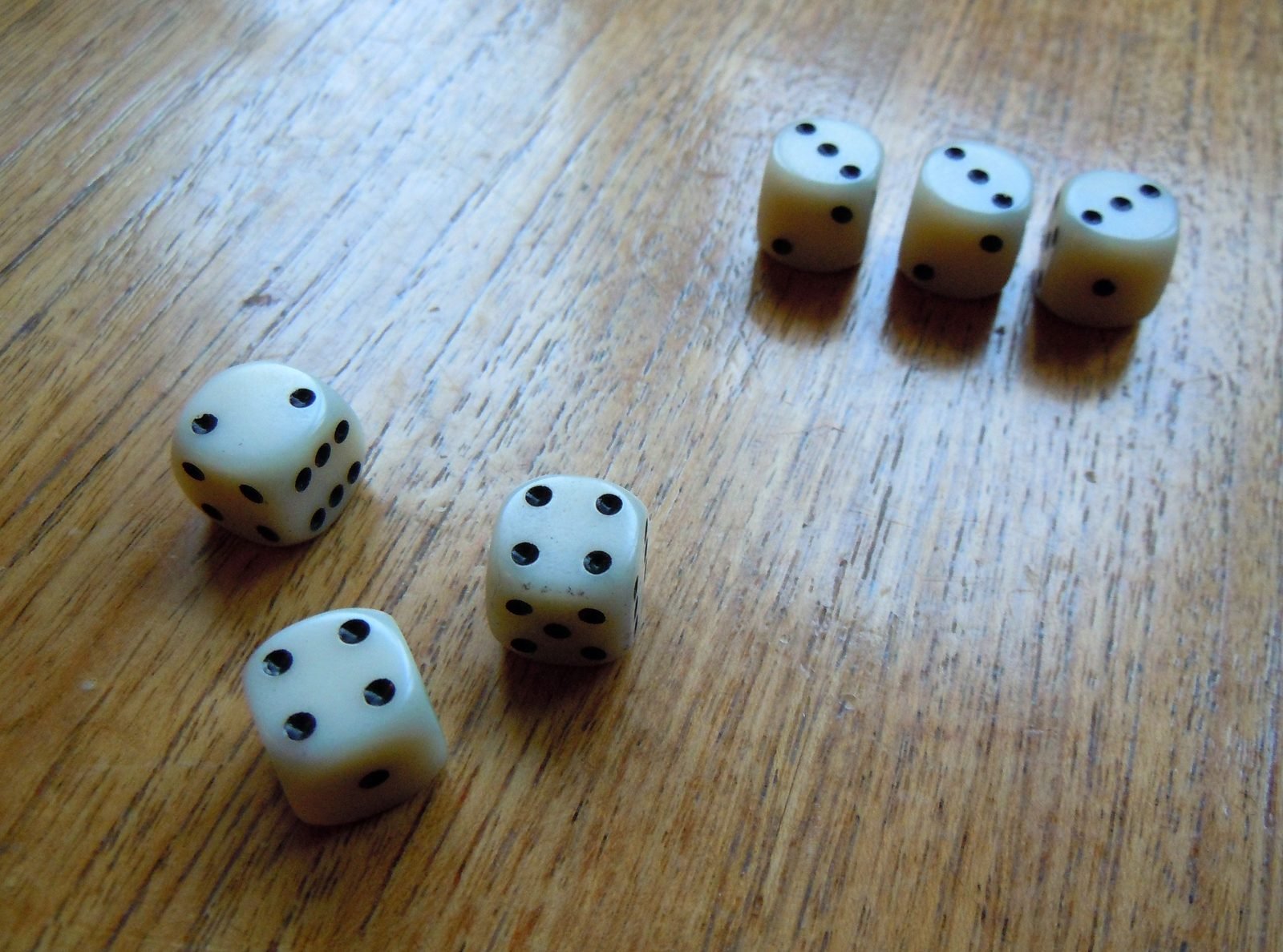 Six dice showing different pip faces scattered together on a table