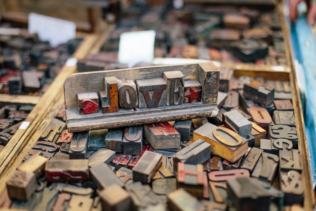 Loose wooden letterpress type blocks in trays, one arrangement spelling the word LOVE